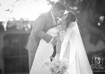 Bride and groom kissing BW