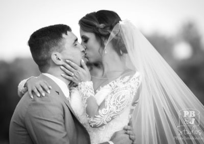 Bride and groom kissing BW