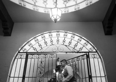 Bride and groom at gate BW